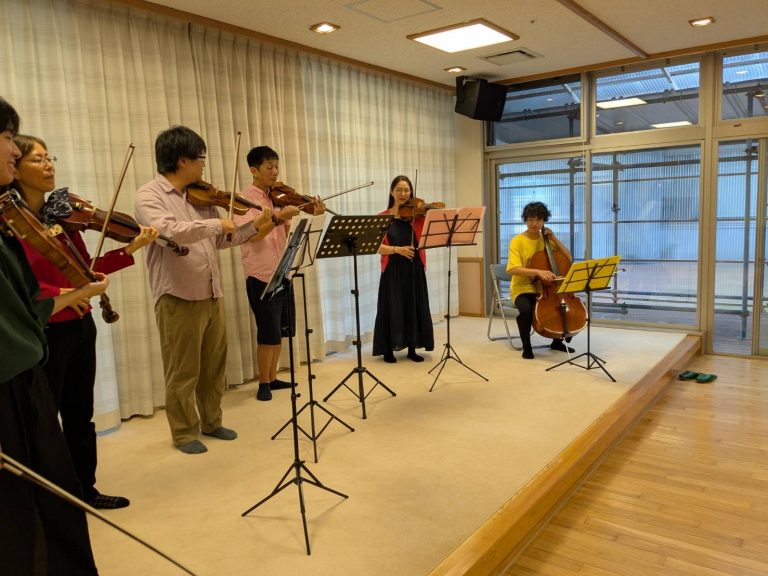 施設内でのクラシック音楽演奏会。複数の楽器奏者による弦楽四重奏の様子。